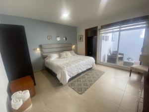 a bedroom with a bed and a large window at Casa Ejecutiva Acogedora Impecable AGS in Aguascalientes
