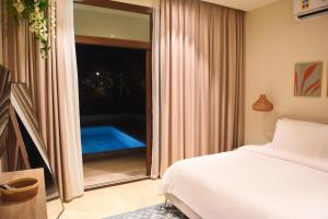 a bedroom with a bed and a window with a swimming pool at Segal Rotana Salalah Villa with private swimming pool in Salalah +29 photos