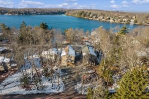 an aerial view of a house on the shore of a lake at New Luxury Lakeview Retreat with Lake Access, HotTub, Game Room, Sleeps 28 in Lake Harmony