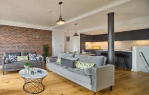 a living room with two couches and a kitchen at Finlays Yard by Veeve in Manchester