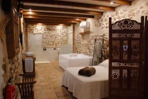 a bedroom with a bed and a bathroom with a tub at El Rincón de San Juan in Marjaliza
