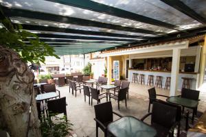 a patio with tables and chairs and a bar at Hotel Maria in Possidi