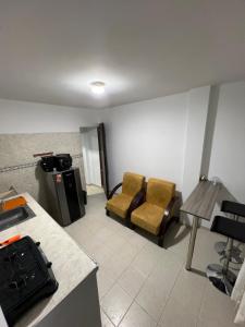 a living room with two chairs and a table at Apartaestudio amoblado - Pasoancho/Sur-Centro/Cali in Cali +9 photos