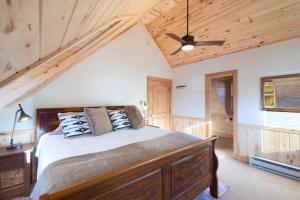 Un dormitorio con una cama y un techo de madera. en The Coach House, en Creede