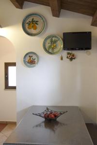 a bowl of fruit on a table with plates on the wall at Terrazza delle mura in Cefalù