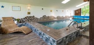 a large swimming pool with a tub in the middle of a room at Štúdio Srnček - Tatranská Štrba - wellness, bazén in Štrba
