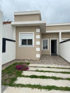 ein Haus mit einem Weg davor in der Unterkunft Casa aconchegante - Green Village - Praia do Cassino in Rio Grande