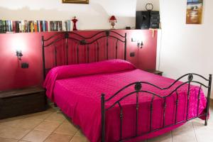 a bedroom with a red bed with a pink bedspread at Terrazza delle mura in Cefalù