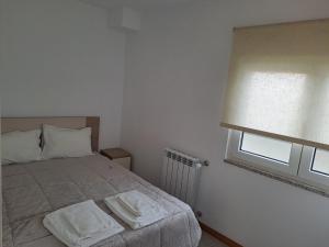 a bedroom with a bed with two towels on it at Casa da Travessa in Seia