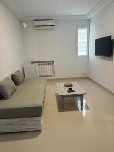 a living room with a couch and a coffee table at La patine des portes in Sfax
