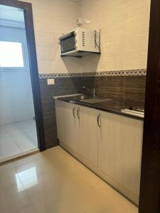 a kitchen with a sink and a microwave at La patine des portes in Sfax