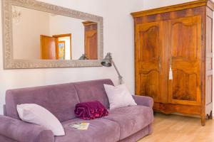 a purple couch in a living room with a mirror at NINA'S HOUSE - Monti Residences in Rome