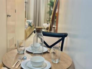 a table with a bottle and two glasses on it at DandD's Place Studio Unit 1 with Free Netflix in Davao City