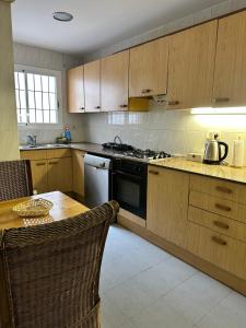 a kitchen with wooden cabinets and a table and a stove at Relax Holiday Home in Vallromanas