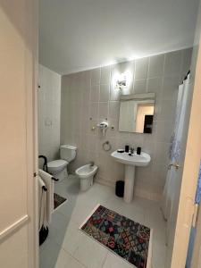 a white bathroom with a toilet and a sink at Relax Holiday Home in Vallromanas