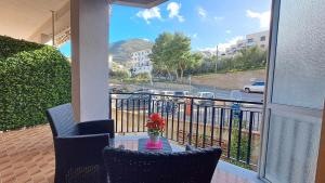 un balcone con 2 sedie e un tavolo con un vaso di fiori di Chez Lucy by Casa in mente a Cefalù