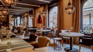 a restaurant with tables and chairs and chandeliers at Bright Urban Cukor Suite - Balcony - Free Parking - Near Arena & Jarun in Zagreb
