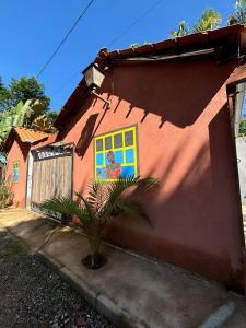 un edificio rosso con un dipinto sul lato di Casa Pouso Tiradentes 3 a Tiradentes