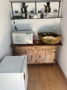 una cucina con un microonde e una ciotola su un tavolo di Casa Pouso Tiradentes 3 a Tiradentes
