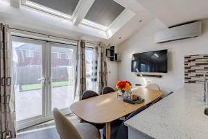 ウェンズベリーにあるSunset View-Luxury 2-Bed House Near Birminghamのテーブルと椅子のあるキッチンとダイニングルーム