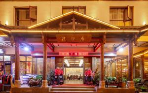 张家界Zhangjiajie Huan Sha Ju Hotel的一群站在建筑物前的人