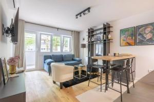 a living room with a blue couch and a table at Bright Urban Cukor Suite - Balcony - Free Parking - Near Arena & Jarun in Zagreb