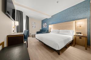 Postel nebo postele na pokoji v ubytování Hotel Zentral Gijón Rey Pelayo