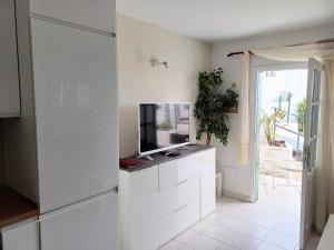 a living room with a tv on a white cabinet at Bright & spacious with aircon in Puerto del Carmen