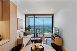 ゴールドコーストにあるThe Horizon - Brand NEW Casino 43F Luxury 2BR unit in Broadbeach with Pool Gym Netflixのソファとテーブルと椅子のあるリビングルーム