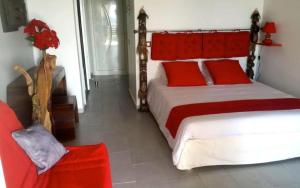 a bedroom with a large bed with red pillows at Studio confortable avec piscine à Saint-François, 35 m² in Saint-François +16 photos