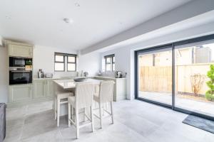 a kitchen with a table and chairs and a large window at The Lodge Private Parking & Garden in Cheltenham