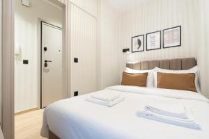 a bedroom with a large white bed with a mirror at GatheringThess- The backyard in Thessaloniki
