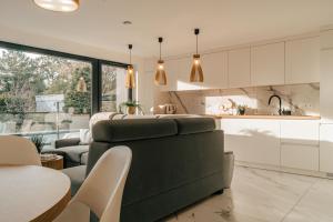 a kitchen and living room with a couch and a table at Balans nad Jeziorem in Ślesin