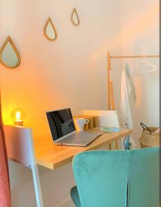 a desk with a laptop computer on top of it at Appartement tout équipé Paris-Colombes- La défense in Colombes