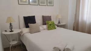 a white bed with pillows on it in a room at URBION HOME in Seville