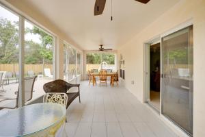 un salón acristalado con una mesa y sillas en un patio en Relax by Pool Port St Lucie Home Near Local Park!, en White City