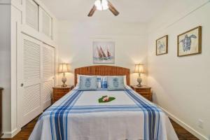 a bedroom with a bed with blue and white sheets at New remodeled Kiahuna Paradise condo in Koloa +16 photos