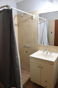 a bathroom with a sink and a shower with a mirror at Casa capital in San Juan