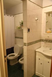 a bathroom with a toilet and a sink at Casa capital in San Juan +12 photos
