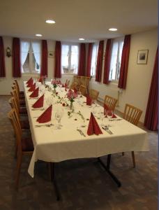 een lange tafel met rode servetten en stoelen bij Hotel Montana in Seelisberg