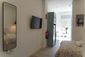 espejo en la pared de un dormitorio con cama en Casa de Huespedes Carabanchel2, en Madrid