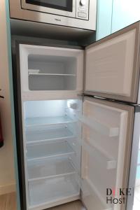 Un refrigerador vacío con un microondas encima. en Casa de Huespedes Carabanchel2, en Madrid 17 fotos más