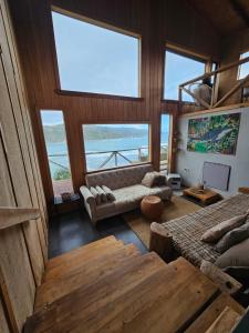 a living room with a view of the ocean at Pumillahue Lodge cabaña matrimonial in Ancud