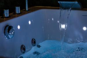 a bath tub with water coming out of it at Love Room Pour un séjour en amoureux in Sotteville-lès-Rouen