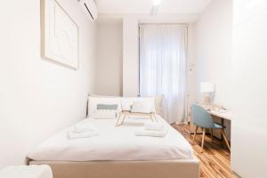 Un dormitorio blanco con una cama y un escritorio. en Easylife - Milano - Unione 2 - Duomo, en Milán