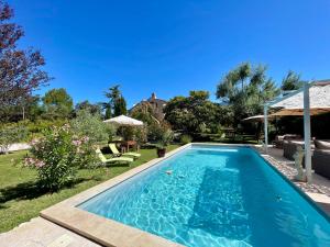 a swimming pool in the backyard of a house at La belle histoire Gîte Montmirail in Bédoin