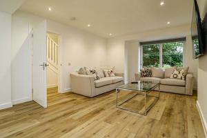 a living room with two couches and a glass table at Wyndford Riverside House in Glasgow