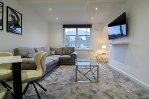 a living room with a couch and a table at Serviced Apartment near Prestwick Airport with Private Parking - Long Stays Available in Prestwick