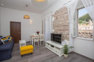 sala de estar con TV, sofá y mesa en Central Apartment, en Dubrovnik