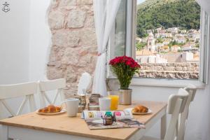a table with food and a window with a view at Central Apartment in Dubrovnik
